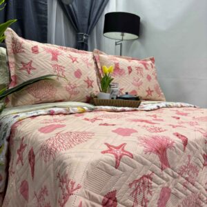 Colcha estampada doble faz en color corales, diseño reversible, ideal para decorar y aportar confort al dormitorio.